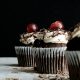 three chocolate cupcakes with cherries
