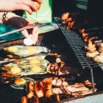 person holding tong with grilled food