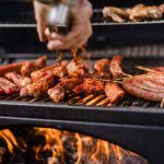 a person is cooking meat on a grill