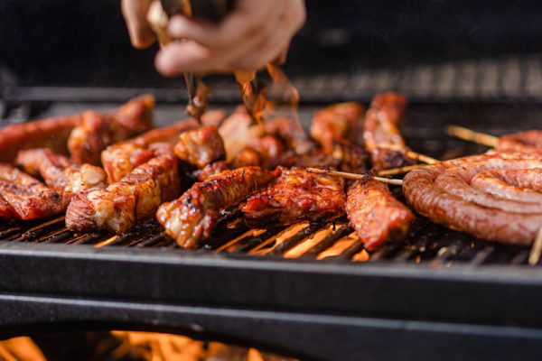 a person is cooking meat on a grill